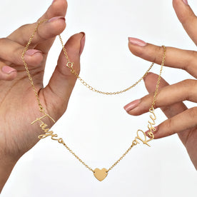 Hands holding Faye and Rosie double name with solid heart necklace on gold anchor chain - Zara font
