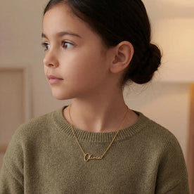 Girl Modelling a Gold Olivia Name Necklace - Anna font