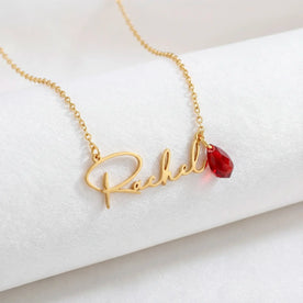 Close up product shot of gold Rachel necklace with birthstone charm - Dahlia font