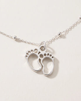 Ketting en armband met bedeltjes van babyvoetjes