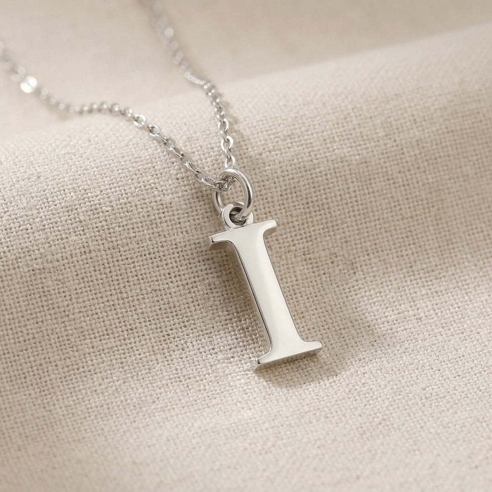 Personalised silver initial necklace with the letter I in the Mia style, close up, showing the polished cut edge and the thickness of the metal.