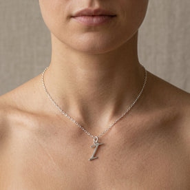 Personalised silver initial necklace with the letter I in the Eva style, worn at the base of the throat.