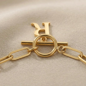 Bracciale con iniziale, catena ovale Belcher a T e ciondoli multipli in oro o argento.