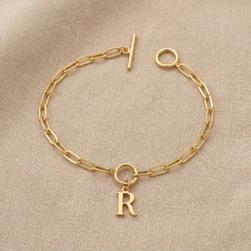 Bracciale con iniziale, catena ovale Belcher a T e ciondoli multipli in oro o argento.