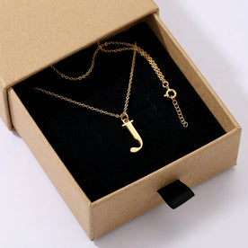 Personalised gold initial necklace with the letter J in the Mia style, presented in the kraft gift box it is sent in.