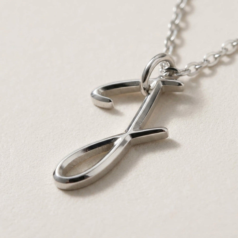 Personalised silver initial necklace with the letter J in the Zara style, close up, showing the polished cut edge and the thickness of the metal.