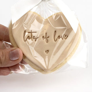 Handmade Lots of Love cookie in beige, close-up in its gift bag