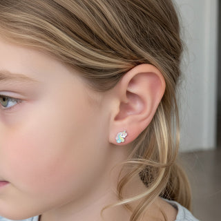 Kids rainbow unicorn stud earring worn on a girl's ear