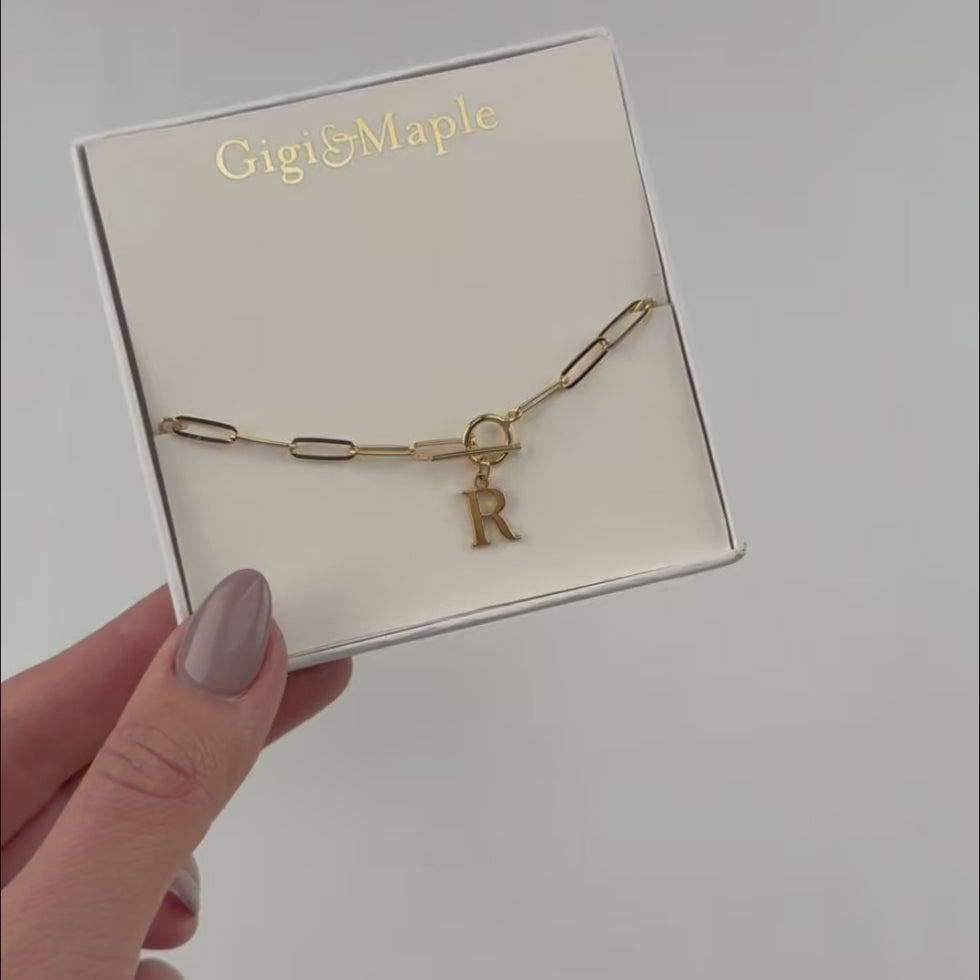 Bracciale con iniziale, catena ovale Belcher a T e ciondoli multipli in oro o argento.
