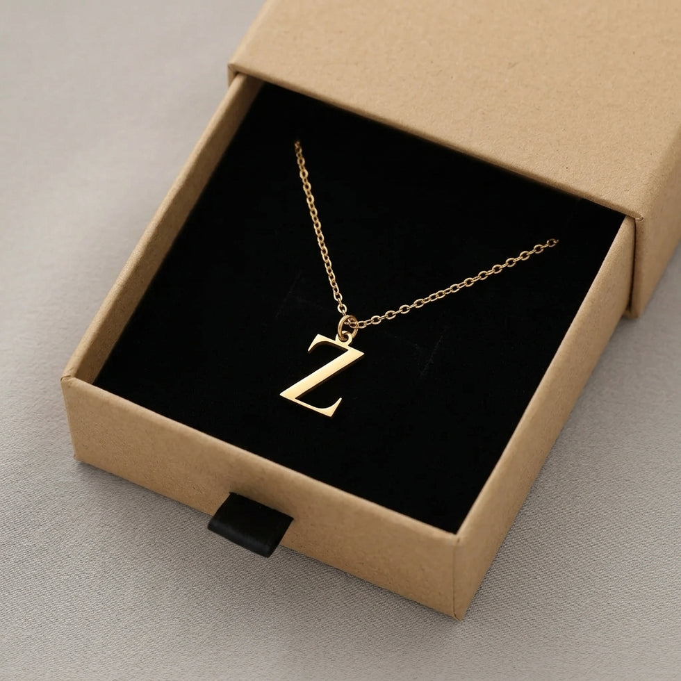 Personalised gold initial necklace with the letter Z in the Mia style, presented in the kraft gift box it is sent in.