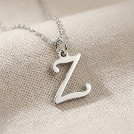 Personalised silver initial necklace with the letter Z in the Zara style, close up, showing the polished cut edge and the thickness of the metal.